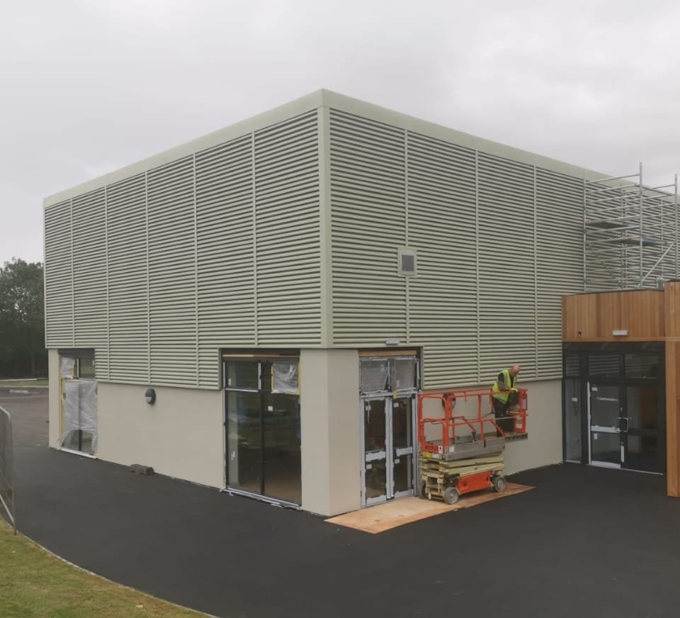 Workman finishing a commercial steel building